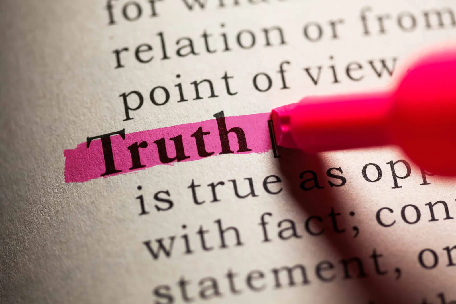 A dictionary page with the word 'Truth' highlighted in pink by a highlighter.