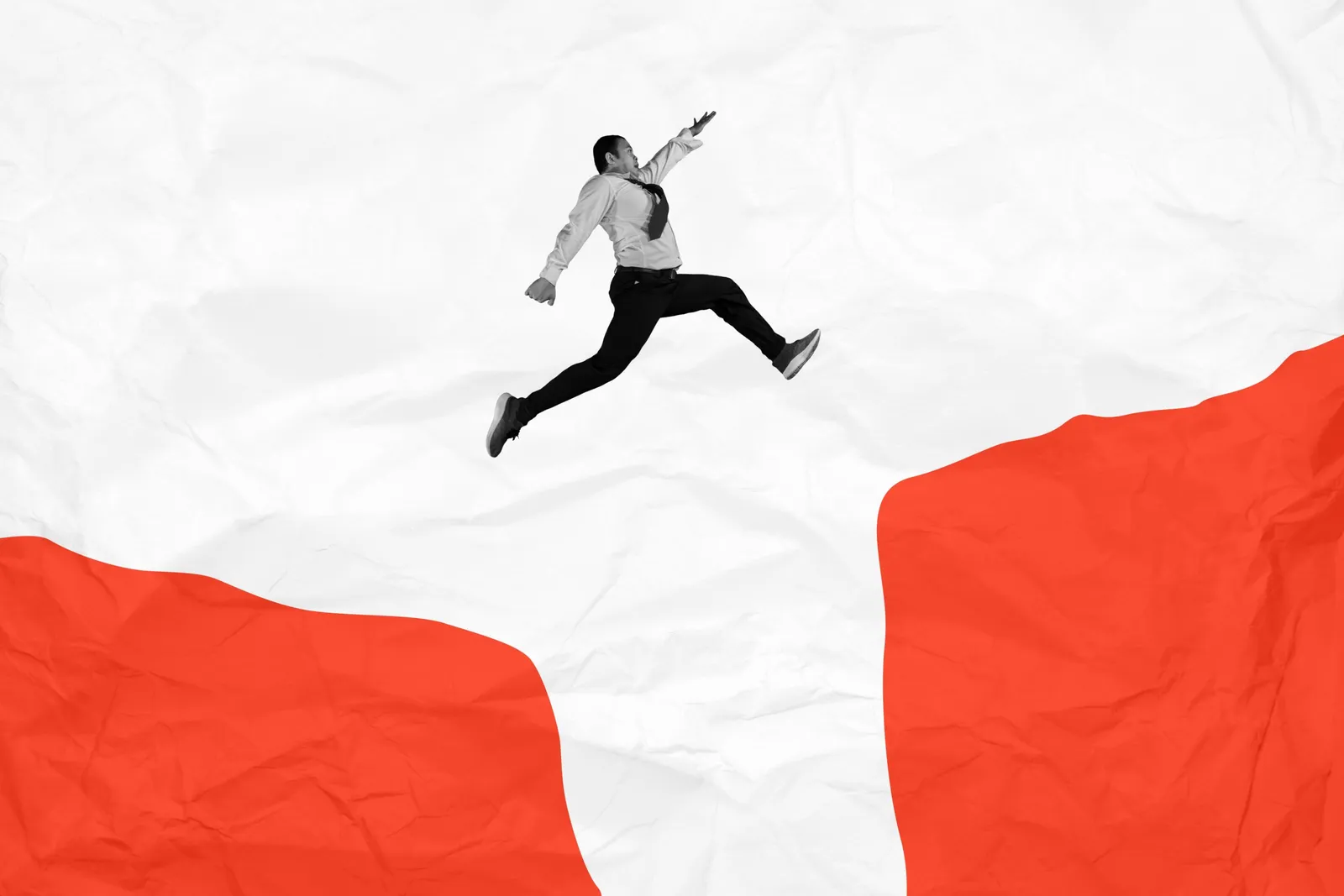 A paper-cutout figure leaps across a gap between two red shapes on a crumpled white background.